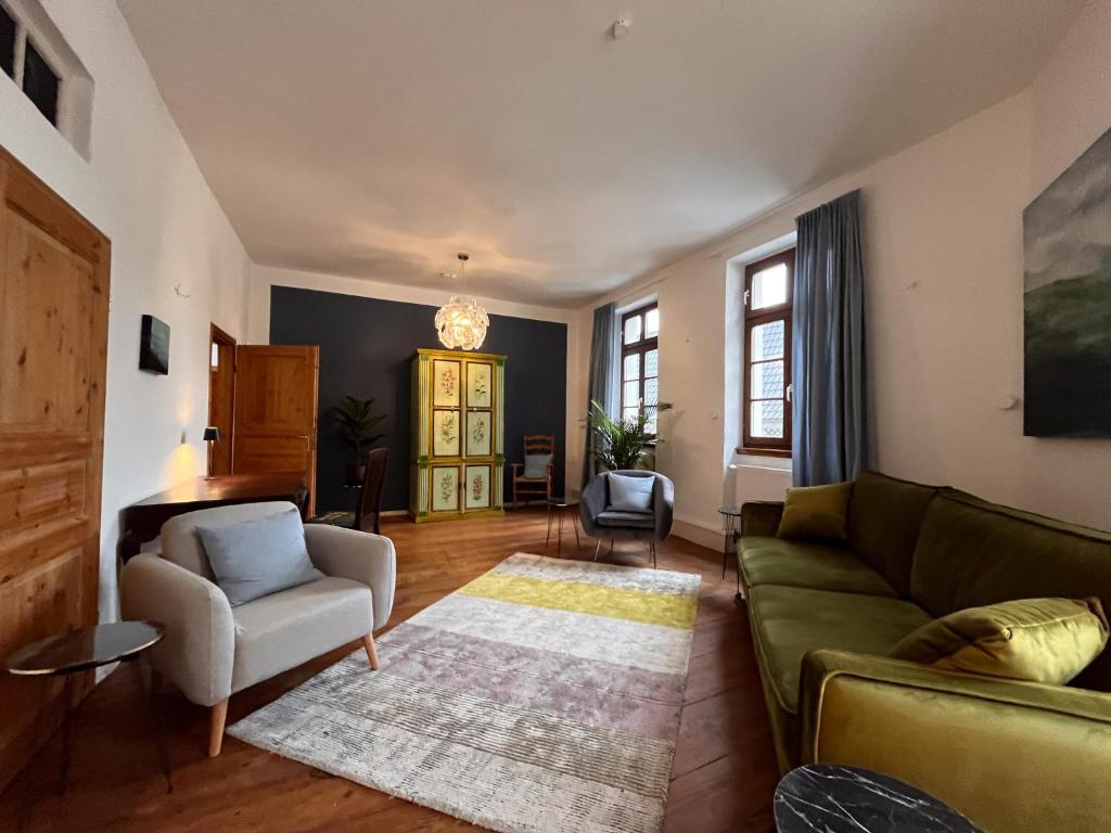 Wohnzimmer mit grünem Sofa und Holzdielen